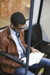 Geschäftsmann beim Lesen eines Buches in der U-Bahn - EBSF000505