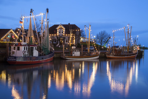 Deutschland, Ostfriesland, Neuharlingersiel, Weihnachtsbeleuchtung am Hafen, lizenzfreies Stockfoto
