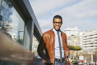 Porträt eines lächelnden Geschäftsmannes mit Lederjacke und Brille - EBSF000516