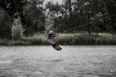 Deutschland, Garbsen, Wakeboarder am Blauen See springt in die Luft - GCF000054