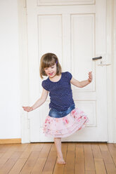 Girl dancing at wooden door - LVF003155
