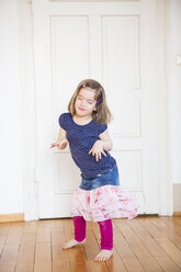 Girl dancing at wooden door - LVF003159