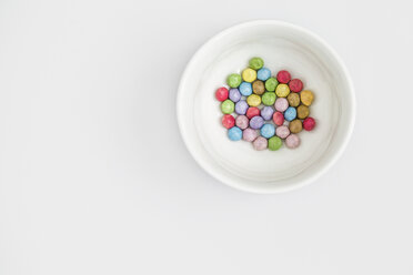 Pastellfarbene Bonbons in einer weißen Schale auf weißem Hintergrund - MELF000055