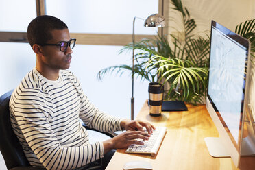 Young creative man working at computer in his home office - EBSF000536