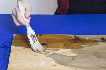 Woman's hand spreading vinegar with brush on a plank - CMF000243
