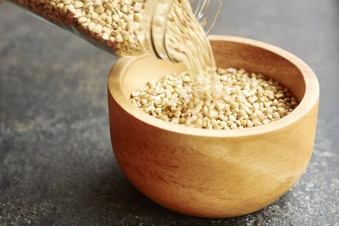 Hemp seeds being poured into a wooden bowl - HAWF000763