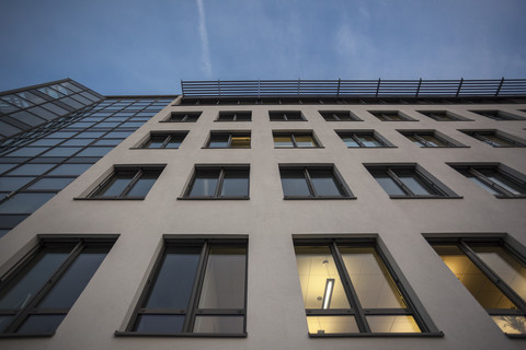 Deutschland, München, Fassade eines Bürogebäudes in der Abenddämmerung, lizenzfreies Stockfoto