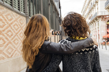 Spanien, Barcelona, zwei junge Frauen machen ein Selfie mit Smartphone auf der Straße - GEMF000174