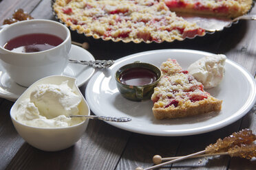 Erdbeer-Rhabarber-Torte mit Schlagsahne und einer Tasse Früchtetee - YFF000366