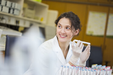 Smiling lab technician holding medical sample - DISF001600