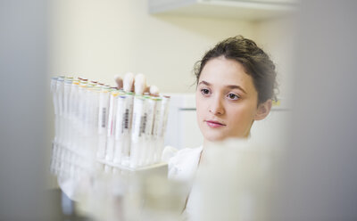 Young lab technician with test tube rack - DISF001603