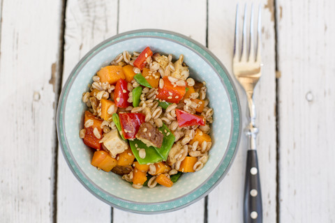 Veganer Salat mit Dinkelweizen, Sesam, Tofu, roter Paprika, Zuckerschoten und Karotten, lizenzfreies Stockfoto