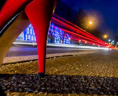 Red high heel and tail lights at night stock photo
