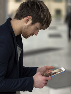 Junger Geschäftsmann mit Mini-Tablet - HCF000114