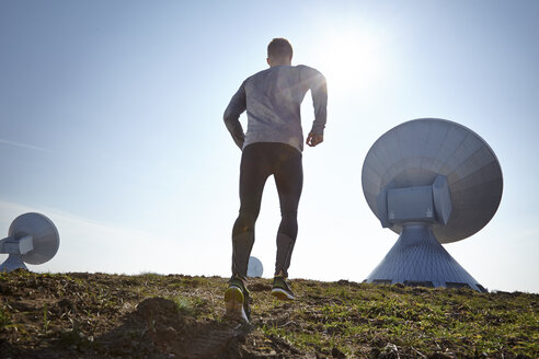 Germany, Raisting, young man jogging at ground station - KDF000703