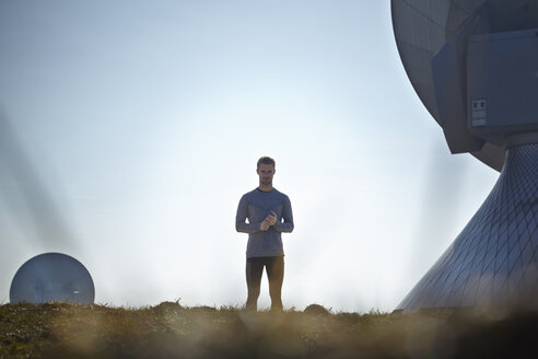 Germany, Raisting, young jogger at ground station - KDF000704