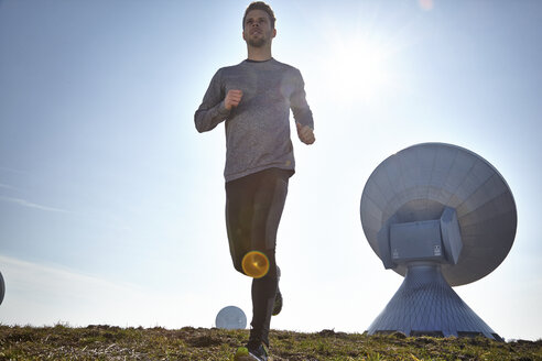 Germany, Raisting, young man jogging at ground station - KDF000710