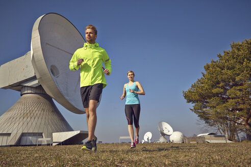 Germany, Raisting, young couple jogging at ground station - KDF000716