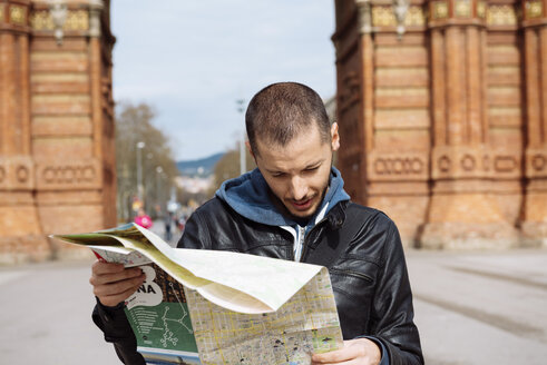 Spanien, Barcelona, Mann schaut auf Stadtplan vor Trymphalbogen - GEMF000180