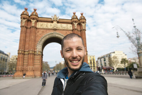 Spanien, Barcelona, glücklicher Mann macht ein Selfie vor dem Trymphal-Bogen - GEMF000183