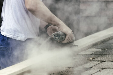 Handwerker mit Schleifmaschine an Betonblock - FRF000242