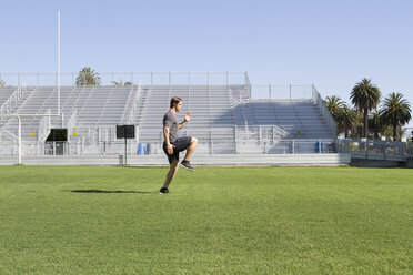 USA, California, San Luis Obispo, young man doing workout on an athletic field - JABF000006