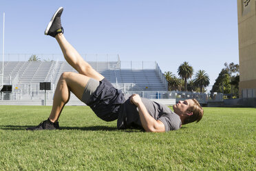USA, Kalifornien, San Luis Obispo, junger Mann beim Training auf einem Sportplatz - JABF000009