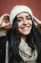 Porträt einer glücklichen jungen Frau mit Wollmütze - MGOF000195
