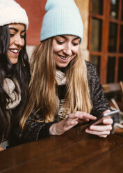 Zwei junge Frauen senden eine Nachricht mit einem Smartphone - MGOF000196