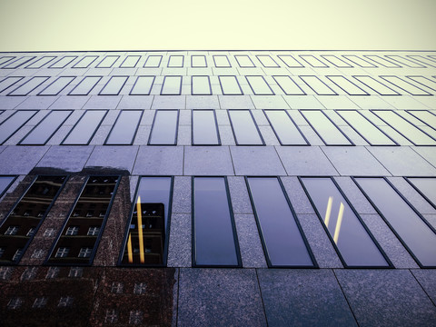 Deutschland, Düsseldorf, Fassade eines modernen Bürogebäudes mit Spiegelung eines anderen Gebäudes, lizenzfreies Stockfoto