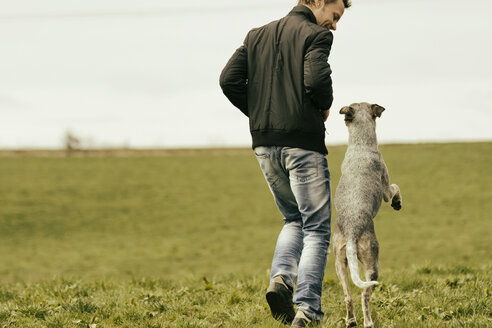 Woman exercising with dog on meadow - ONF000821