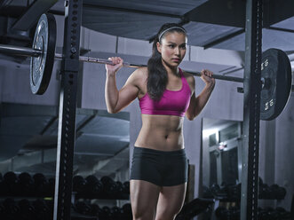 Young woman doing weightlifting with barbell - MADF000168