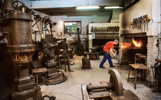 Älterer Schmied bei der Arbeit im Hammerwerk - HHF005305