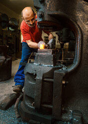 Senior blacksmith working in hammer mill - HHF005314