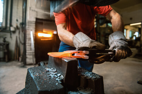 Älterer Schmied bei der Arbeit im Hammerwerk - HHF005328