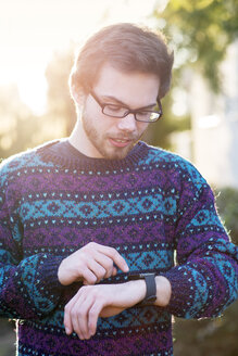 Junger Hipster mit Smartwatch im Gegenlicht - BRF001184