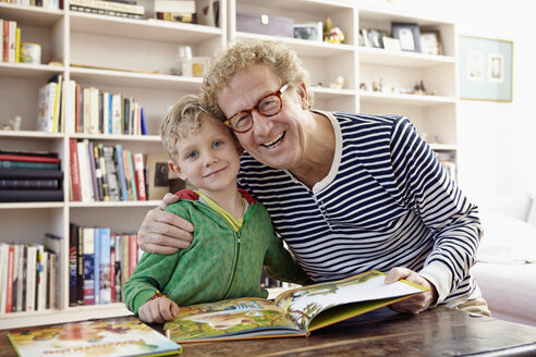 Großvater und Enkel lesen gemeinsam ein Kinderbuch - RHF000754