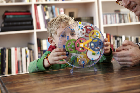 Junge spielt mit Spielzeuguhr, lizenzfreies Stockfoto