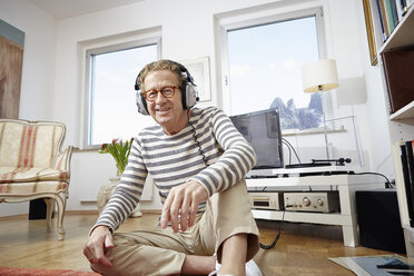 Senior man wearing headphones, listening to music - RHF000764