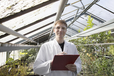 Scientist examining plants in greenhouse - SGF001519