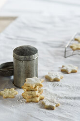 Star shaped shortbreads and powdered sugar sifter on white cloth - ASF005580