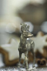 Roe deer figurine made of tin in front of cinnamon stars - ASF005584