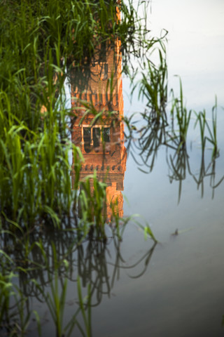 Italien, Roncade, Spiegelung eines Turms auf der Wasseroberfläche eines Wassergrabens, lizenzfreies Stockfoto