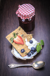 Jam jar, slice of crispbread, curd and fruits on wood - VTF000416