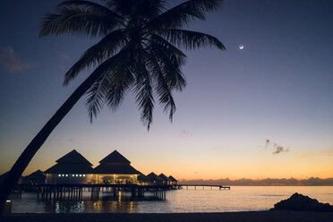 Malediven, Ari Atoll, Sonnenuntergang mit Palmen und Wasservillen - FLF000931
