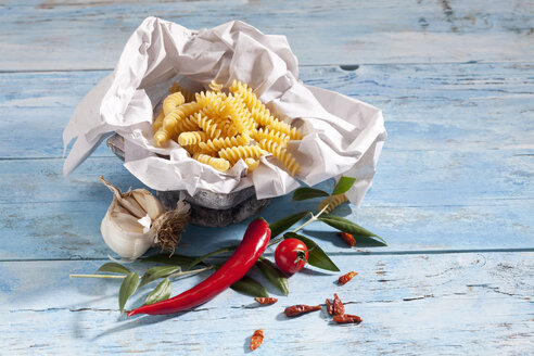 Ungekochte Fusilli, Chilischoten, Knoblauch, Chilischote und Olivenzweig - CSF025294