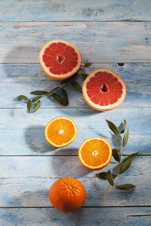 Rosa Grapefruit in Scheiben, ganze und in Scheiben geschnittene Orangen auf Papier - CSF025323