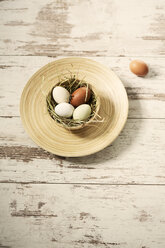 Easter nest with eggs in bowl on wood - MAEF010247