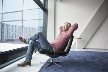 Man relaxing in a leather chair at home - RBF002612