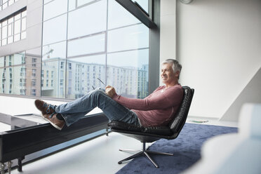 Man relaxing in a leather chair at home - RBF002621